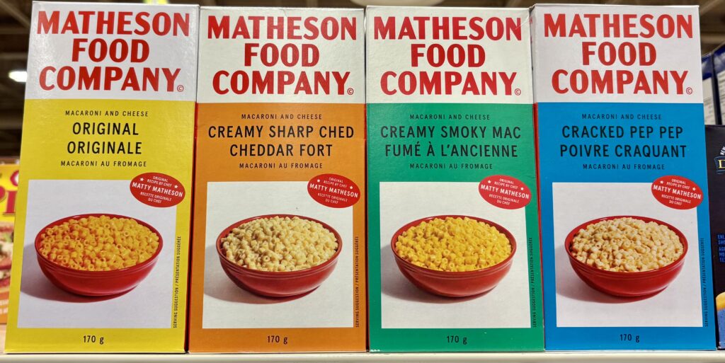 Boxes of Matheson Food Company macaroni and cheese mixes side by side with different coloured boxes for the four different flavours.