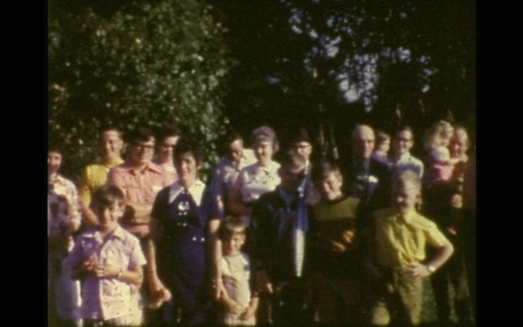 A group of people facing the camera, with trees in the background