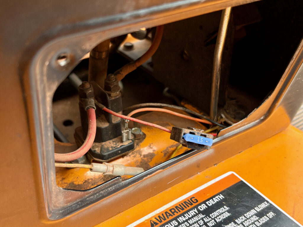 A blue 15 amp fuse with wires around it.