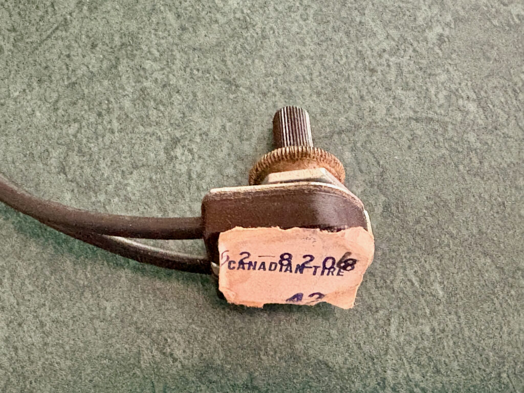 Brown rotary lamp switch with 42 cent Canadian Tire price tag on bottom.